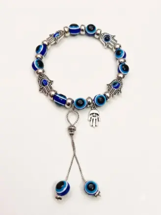 Handmade blue evil eye bracelet with silver Hamsa charms and decorative dangling bead accents.